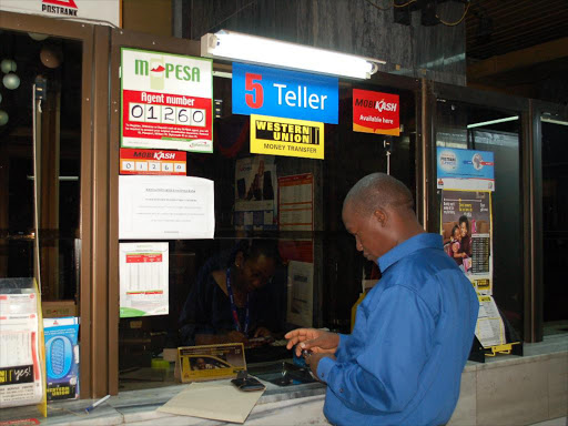 A man at a teller box in the loss making post bank