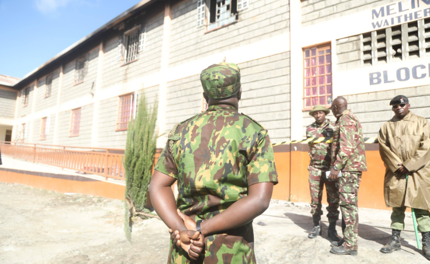 police officers secure the perimeter of a burnt domitory at Utumishi Girls in GilGil.